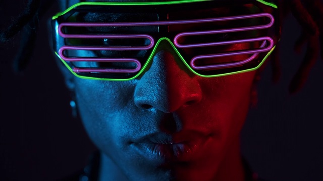 在紫外线下戴着发光眼镜的男人视频素材