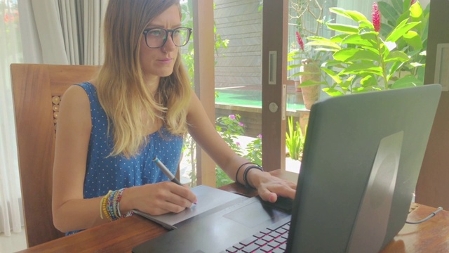 在家里使用笔记本电脑的女人。视频下载