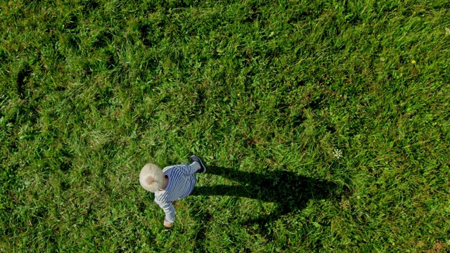 SLO MO CS金发小男孩在阳光明媚的草地上放飞气球视频素材