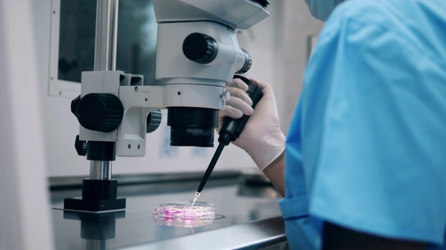 医学实验室工作人员正在显微镜下观察液体视频素材