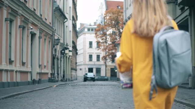 带着地图的女孩走在市中心的街道上。视频素材