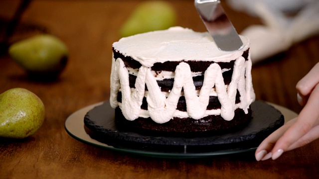 用糖果抹刀在蛋糕上涂奶油的过程。视频素材