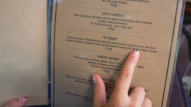 近距离的女人手指与菜单选择菜肴在餐厅视频下载