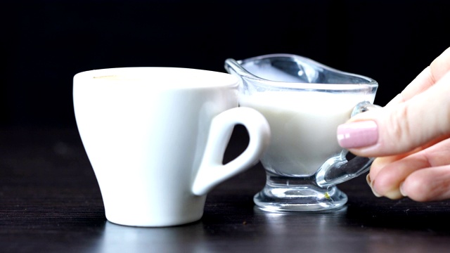 奶油被倒入一杯热咖啡中视频下载