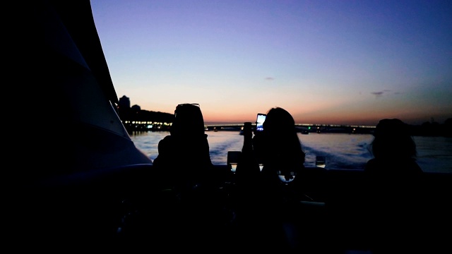 移动电话。游艇上人们的剪影，用手机拍照。视频素材