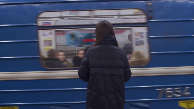 年轻女子在室内等待地铁列车的背影慢镜头。视频素材