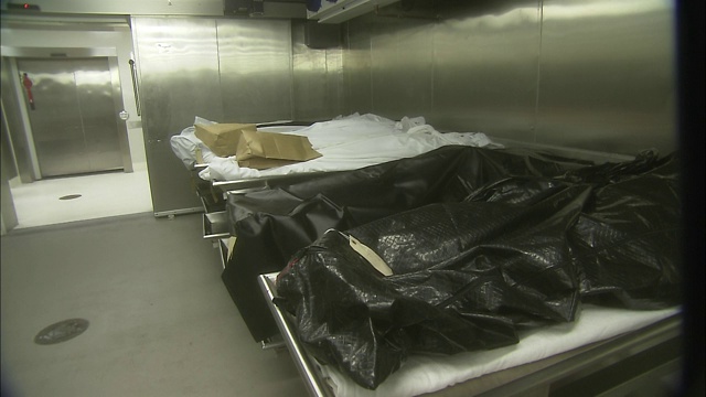 停尸房的墙上挂着轮床上的装尸袋。视频下载