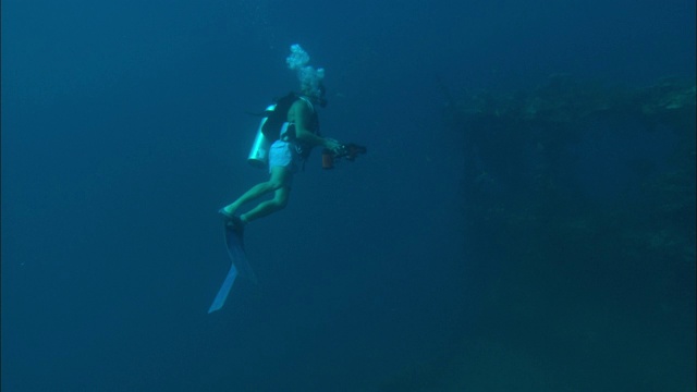 一名潜水员在拍摄海难。视频素材