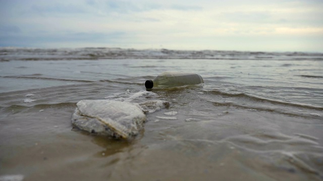 以海洋为背景的海滩上的塑料垃圾和垃圾，概念拯救世界和海滩污染视频素材