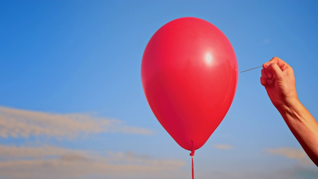SLO MO LD手用针戳破一个红色气球视频下载