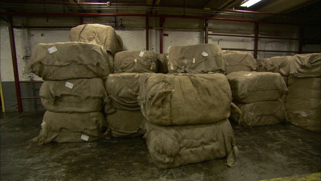 一捆捆的棉花塞满了一个仓库。视频下载