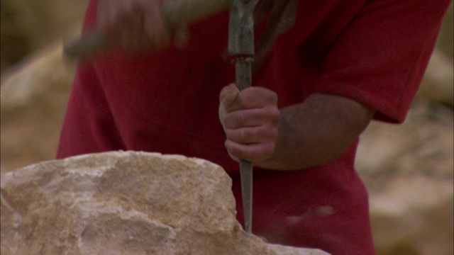 一个罗马士兵在凿石头。视频素材