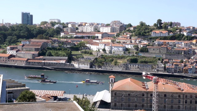 4k平移拍摄的波尔图天际线城市景观，传统葡萄牙船只沿着杜罗河航行。视频下载
