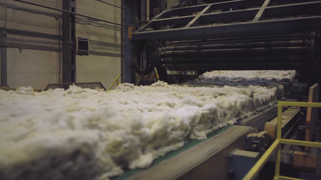 沿生产线移动的蓬松矿棉原料块视频素材
