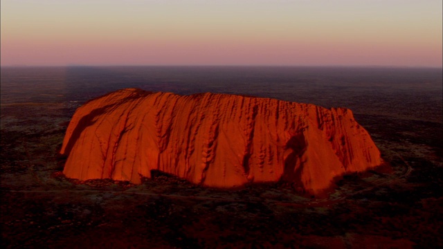 鸟瞰图描绘了夕阳下的乌卢鲁砂岩岩层视频下载