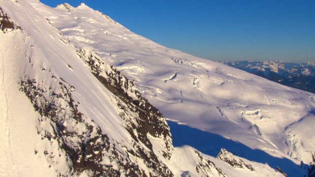 厚厚的积雪覆盖着崎岖的山坡。视频下载