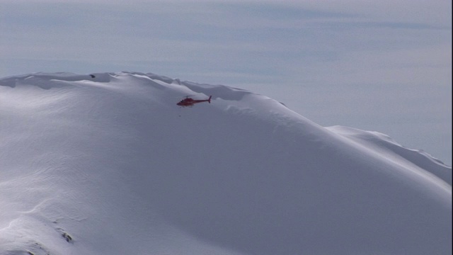 一架直升飞机飞过一座雪山。视频下载