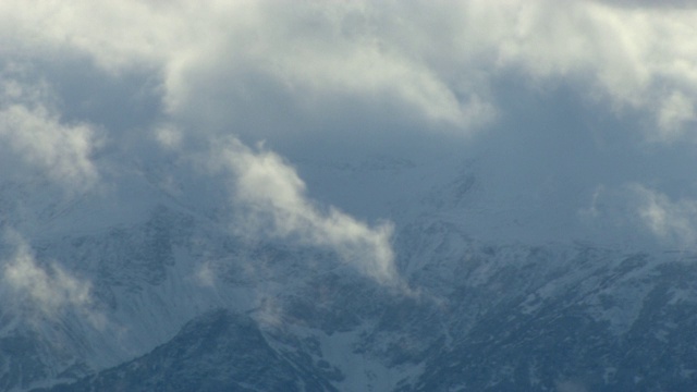 浓密的云层覆盖着一座山。视频下载