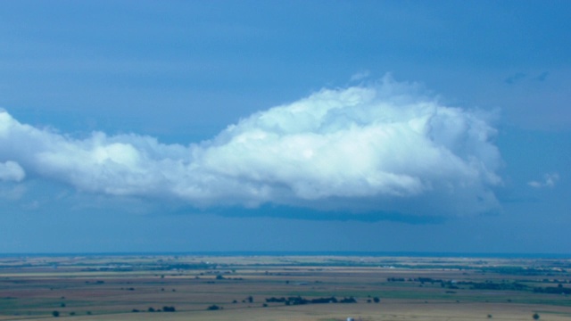 巨大蓬松的云漂浮在农田上。视频下载