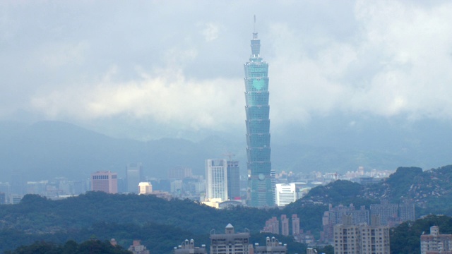 台湾一座摩天大楼高耸于周围的建筑物之上。视频素材