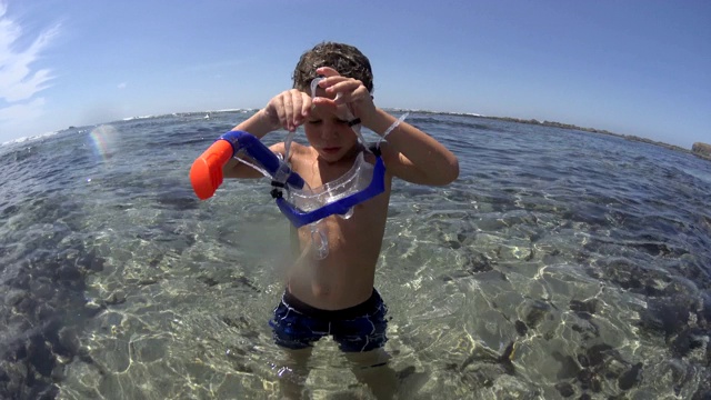 年轻的白种人男孩浮潜与面罩和浮潜在海水，夏天，假期视频下载