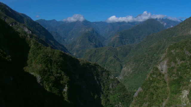 茂密的植被覆盖着崎岖的山脉和悬崖峭壁。视频下载