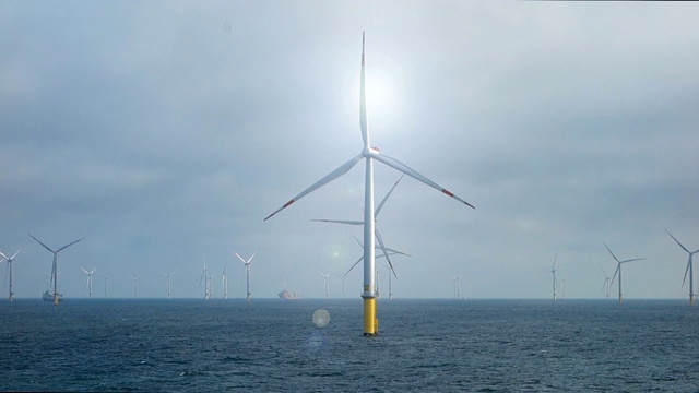欧洲海上风力发电场在充分生产与船舶在背后和上面的太阳视频素材