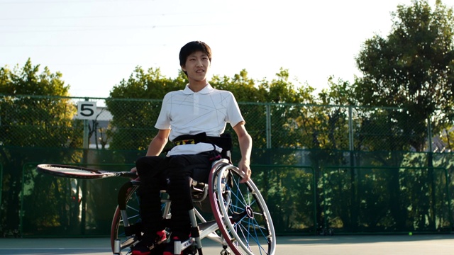SLO MO广角镜头，一个青少年适应运动员在轮椅上打网球视频下载