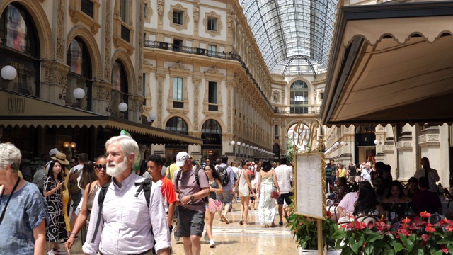 游客和当地人在著名的埃马努埃莱二世Galleria Vittorio Emanuele II购物和午餐的剪辑。视频下载