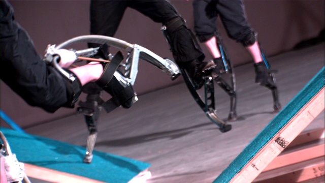 三对腿在由弹簧驱动的装置上奔跑和跳跃。视频下载