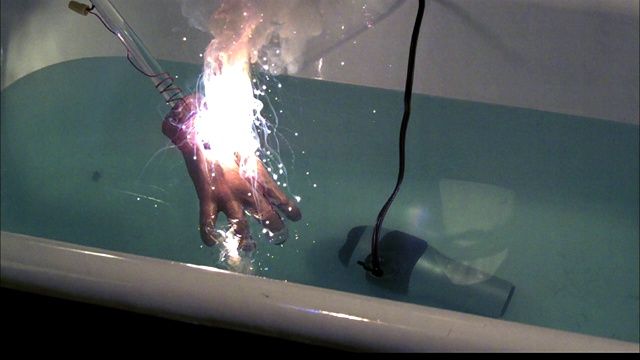 在浸没在水中的吹风机里，一只人造手突然着火。视频下载