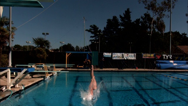 两名跳水运动员从跳板上跳入游泳池。视频下载