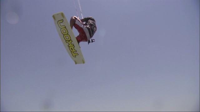 风筝冲浪者滑翔过水面，然后从波浪上跳到空中。视频下载