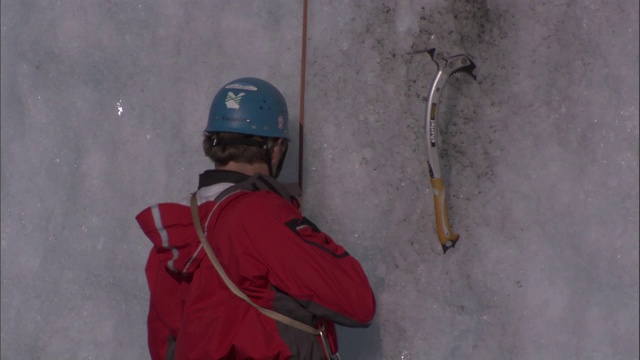 登山者攀登阿拉斯加被冰雪覆盖的悬崖。视频素材