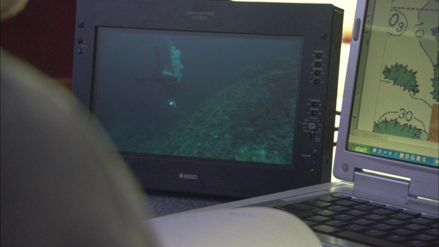 电脑屏幕播放着潜水员在水下的录像。视频下载