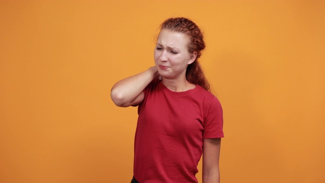 穿着红衬衫的年轻女子一直把手放在脖子上，痛苦地做着鬼脸视频下载