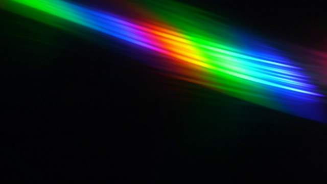 黑色背景上的彩色光束和光线。抽象背景彩虹CD。美丽的彩色镜头光彩虹光束电影和电影院在晚上。将光线分成光谱颜色的棱镜。视频下载