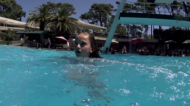 小女孩在游泳池里跳跃和跳水-慢动作-视频下载