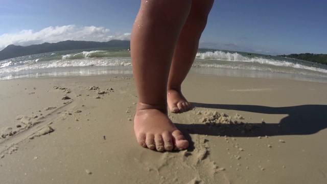 在海滩/海边散步的婴儿/蹒跚学步的小孩。脚近距离。高清视频下载