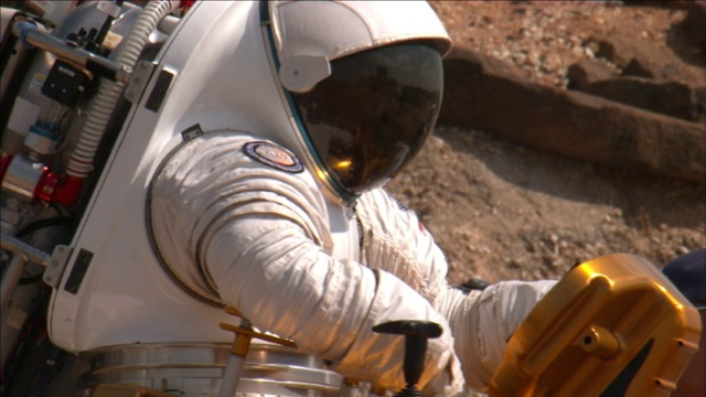 一名美国宇航局宇航员在沙漠地带驾驶一辆月球卡车。视频素材