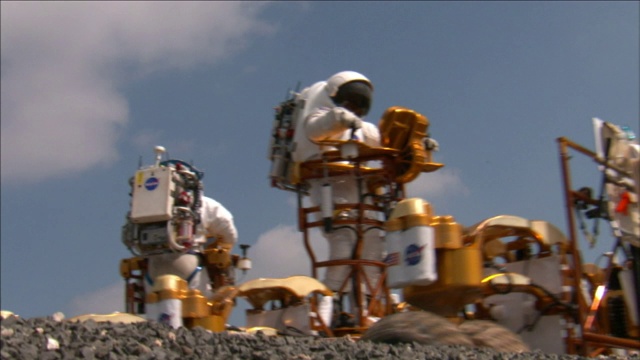 穿着全套太空装备的美国宇航局宇航员驾驶月球卡车穿越崎岖的地形。视频素材