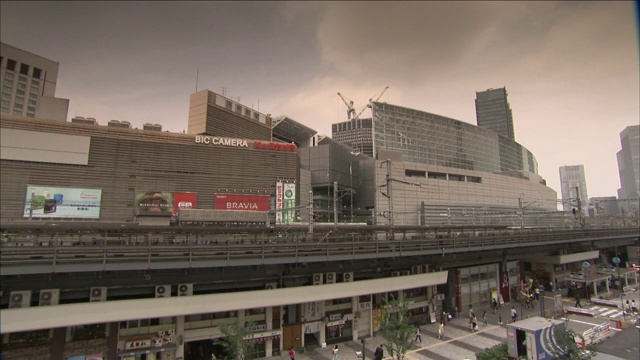 东京，一列通勤列车快速驶过写字楼。视频素材
