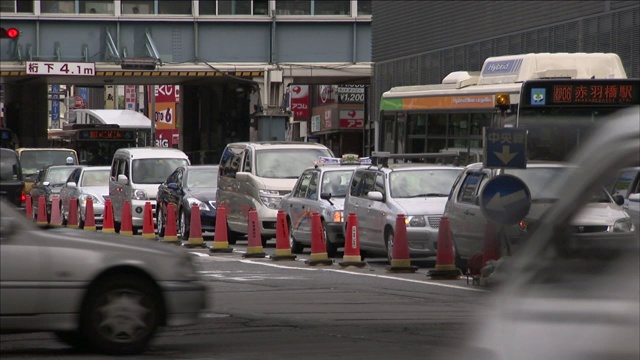 车辆穿过繁忙的十字路口旁边的一排交通锥。视频素材