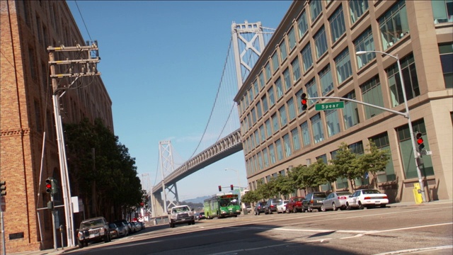 一辆城市公交车在旧金山海湾大桥附近的街道上转弯。视频素材