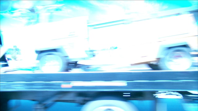 一辆汽车在高速公路上超过卡车和其他车辆。视频素材