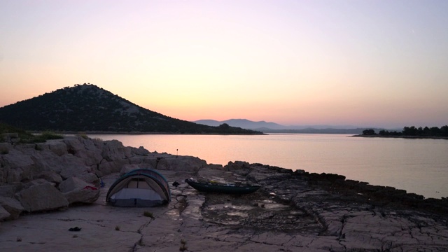 在岛上露营，用帐篷和船在海边在夏天的早晨日出视频素材