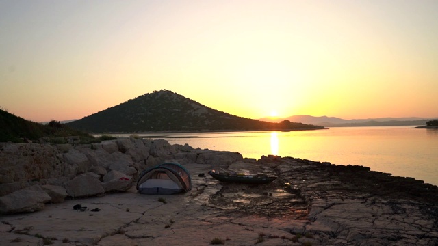 在岛上露营，用帐篷和船在海边在夏天的早晨日出视频素材