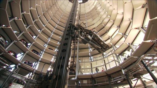 一个巨大的液压升降机将一辆汽车抬到塔中的一个存储空间。视频素材