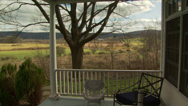 露台上摆放着长凳，可以俯瞰广阔的绿色田野和远处低矮的山脉。视频下载