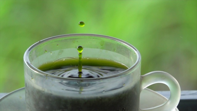 绿茶滴在杯子上的慢动作视频下载